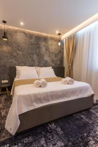 萨拉热窝Mayisa Apartments的一间卧室配有一张大床和毛巾