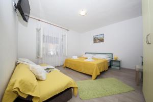 图彻皮Apartments by the sea Tucepi, Makarska - 11486的配有黄色床单的客房内的两张床