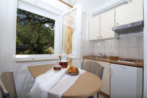 图彻皮Apartments by the sea Tucepi, Makarska - 11486的厨房里配有一张桌子,上面有盘子的食物