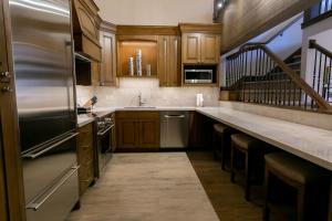 帕克城Sultan Studio Loft Hotel Room的厨房配有木制橱柜和不锈钢冰箱。