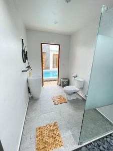 威廉斯塔德Moringa Resort - Studio B with Pool, open Air Shared Shower Bath的带淋浴、卫生间和盥洗盆的浴室