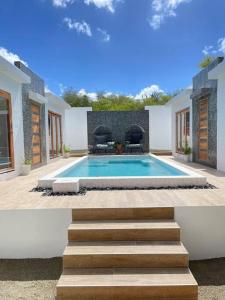 威廉斯塔德Moringa Resort - Studio B with Pool, open Air Shared Shower Bath的一座房子后院的游泳池