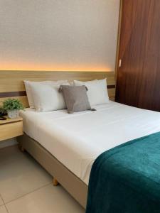 维多利亚Flat PRAIA de Camburi的一张大白色的床,位于酒店客房内