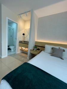 维多利亚Flat PRAIA de Camburi的一间带大床的卧室和一间浴室