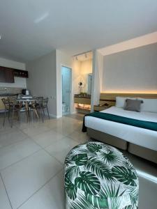 维多利亚Flat PRAIA de Camburi的一间卧室配有一张床,另一间卧室配有一张搁脚凳