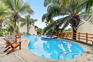 科克Colorful, Classy, Modern Split-Level Near Beach with Pool的一个带两把椅子的游泳池,棕榈树