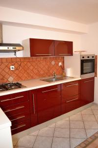 尼亚卢卡Apartments by the sea Vela Luka, Korcula - 11455的一间带红色橱柜和水槽的厨房