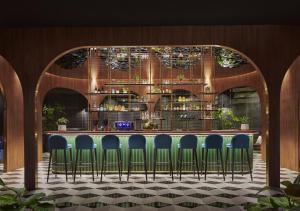 吉隆坡吉隆坡宾乐雅臻选酒店的吧台前的酒吧,带蓝色椅子