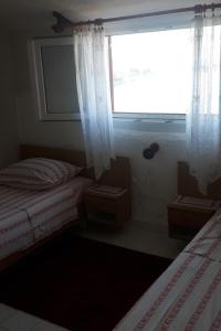 普尔维奇卢卡Apartments by the sea Prvic Luka, Prvic - 13845的一间卧室设有两张单人床和一个窗户。