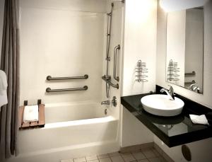 麦迪逊高地Travelodge by Wyndham Madison Heights MI的白色的浴室设有水槽和淋浴。