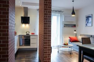 什切青斯塔卡公寓- 河滨的厨房以及带砖墙的起居室。