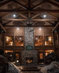 北康威New England Inn & Lodge的一座在雪中设有石头壁炉的建筑