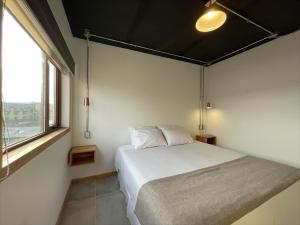 纳塔列斯港Hotel Big Sur的一间卧室设有一张床和一个大窗户