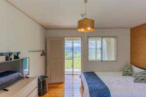 恩纳Hermit Hills Okinawa  -SEVEN Hotels and Resorts-的一间卧室配有一张床和一台平面电视