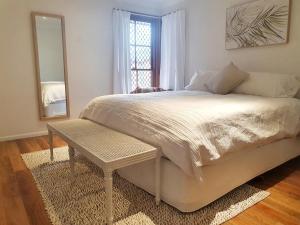奥尔伯里Olive Street Apartment的一间卧室配有一张带桌子和镜子的床