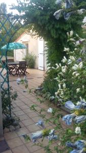 ViréPis-en-lits的一个带鲜花、桌子和遮阳伞的庭院