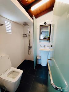 康提The Heritage Inn的浴室配有卫生间、盥洗盆和浴缸。