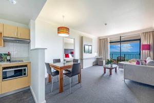 达尔文Two Private Oceanview Suites with Resort Pool的厨房以及带桌椅的起居室。