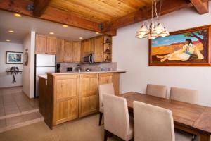 阿斯潘1 Bedroom Mountain Residence In The Heart Of Aspen With Amenities Including Heated Pool, Hot Tubs, Game Room And Spa的厨房以及带桌子和冰箱的用餐室