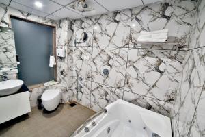 苏拉特Hotel Kings Heritage Surat的带浴缸、卫生间和盥洗盆的浴室
