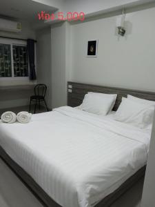 巴真府The grace kok udom的卧室配有一张白色大床和两条毛巾