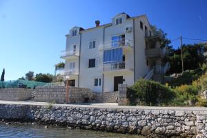 斯拉诺Apartments by the sea Slano, Dubrovnik - 8741的水边小山上的白色房子