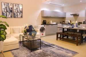 马斯喀特Stylish Apartment with a Jacuzzi (Park&Pool View)的带沙发和桌子的客厅以及厨房。