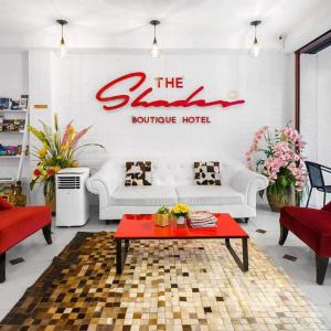 芭东海滩The Shades Hotel 50 meter Beach Front的客厅配有白色沙发和红色桌子