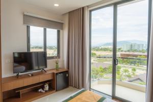 Tan AnJAP KARO的酒店客房设有电视和大窗户。
