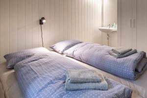 OlsborgHøgtun kulturklynge的客房内的两张床和毛巾