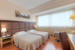 阿雷佐米尼尔瓦酒店的酒店客房设有两张床和窗户。
