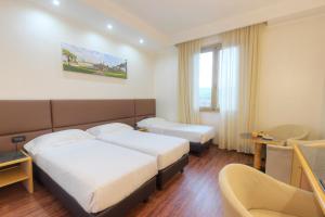 阿雷佐米尼尔瓦酒店的酒店客房设有两张床和一张桌子。