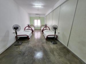 Kampong MortenVintage Inn的一间医院,配有四张床和镜子
