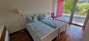 伯尔尼Senevita Wangenmatt的一间卧室配有一张蓝色床单和一个阳台。