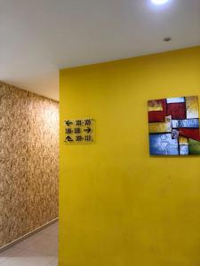 雪邦M Design Hotel@KLIA,Sepang的黄色的墙,上面有标志
