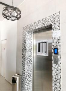 雪邦M Design Hotel@KLIA,Sepang的浴室设有玻璃淋浴间,浴室设有瓷砖墙