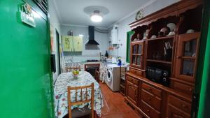 加尔达尔Casa de Abuela Petra的厨房配有桌子和绿色的墙壁