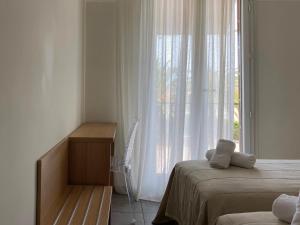 波尔蒂乔博迪西欧酒店的一间卧室配有床和白色窗帘的窗户