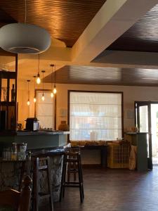 波尔蒂乔博迪西欧酒店的厨房设有带凳子和窗户的酒吧