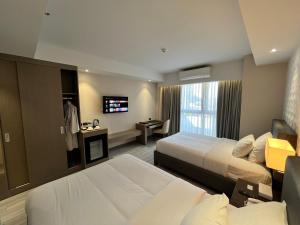 安吉利斯Capitol Hill Hotel and Suites的酒店客房设有两张床和电视。