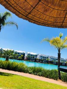 比勒陀利亚Blyde Luxury Apartment的享有带游泳池和棕榈树的度假村的景致