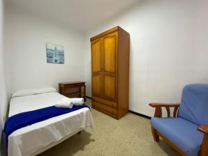 圣克鲁斯-德拉帕尔马罗卡玛酒店的一间卧室配有一张床、一个橱柜和一把椅子