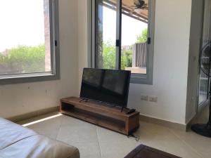 艾因苏赫纳einbay 3 bedrooms garden + pool view的客厅的桌子上配有平面电视