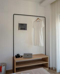普萨克迪亚Aiora Suites by Booking Kottas的墙上挂着白色连衣裙的镜子