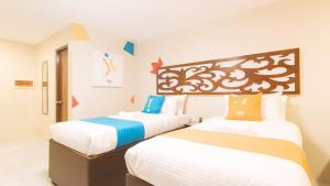 马尼拉Sans Hotel at Algers Suites Marikina by RedDoorz的配有两张床的酒店客房中的两张床