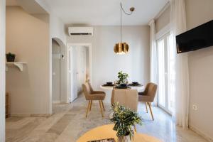 塞维利亚Magno Apartments Guadalquivir Terrace的客厅设有餐桌和椅子