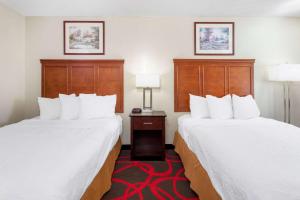 里士满Travelodge by Wyndham Richmond IN的酒店客房设有两张床和两盏灯。