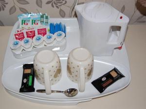 布莱克浦亚特兰蒂斯酒店的一个带茶壶和汤匙的托盘