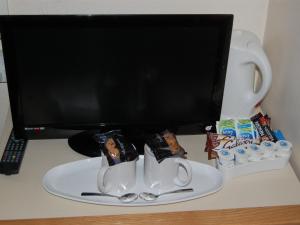 布莱克浦亚特兰蒂斯酒店的一张带电脑显示器和两个咖啡杯的桌子