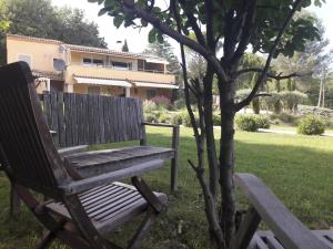 圣萨蒂南艾普特Les Cerises的木凳坐在树旁的草上
